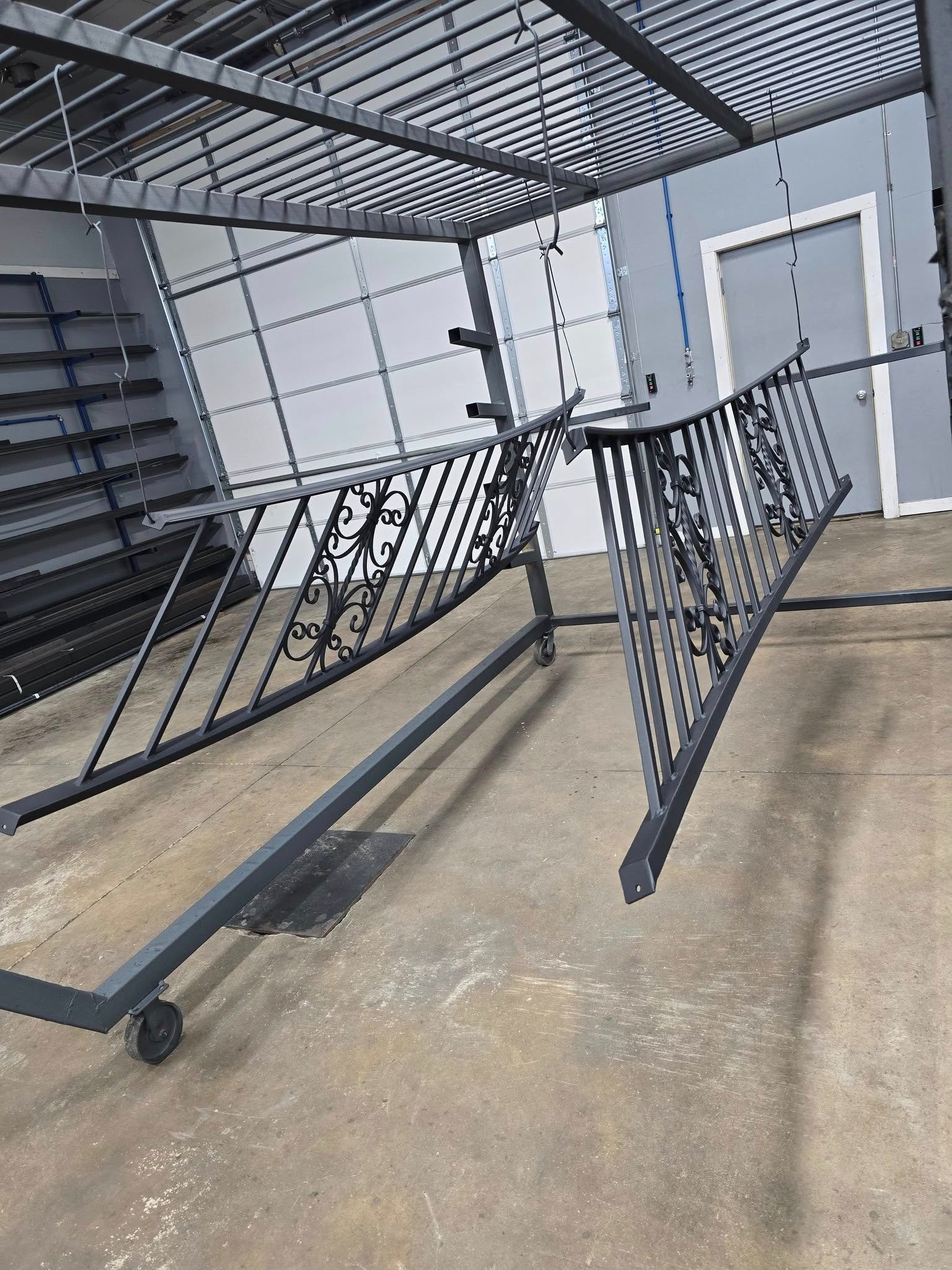 Collapsed metal barricade in an outdoor stairwell area beside a gray building.