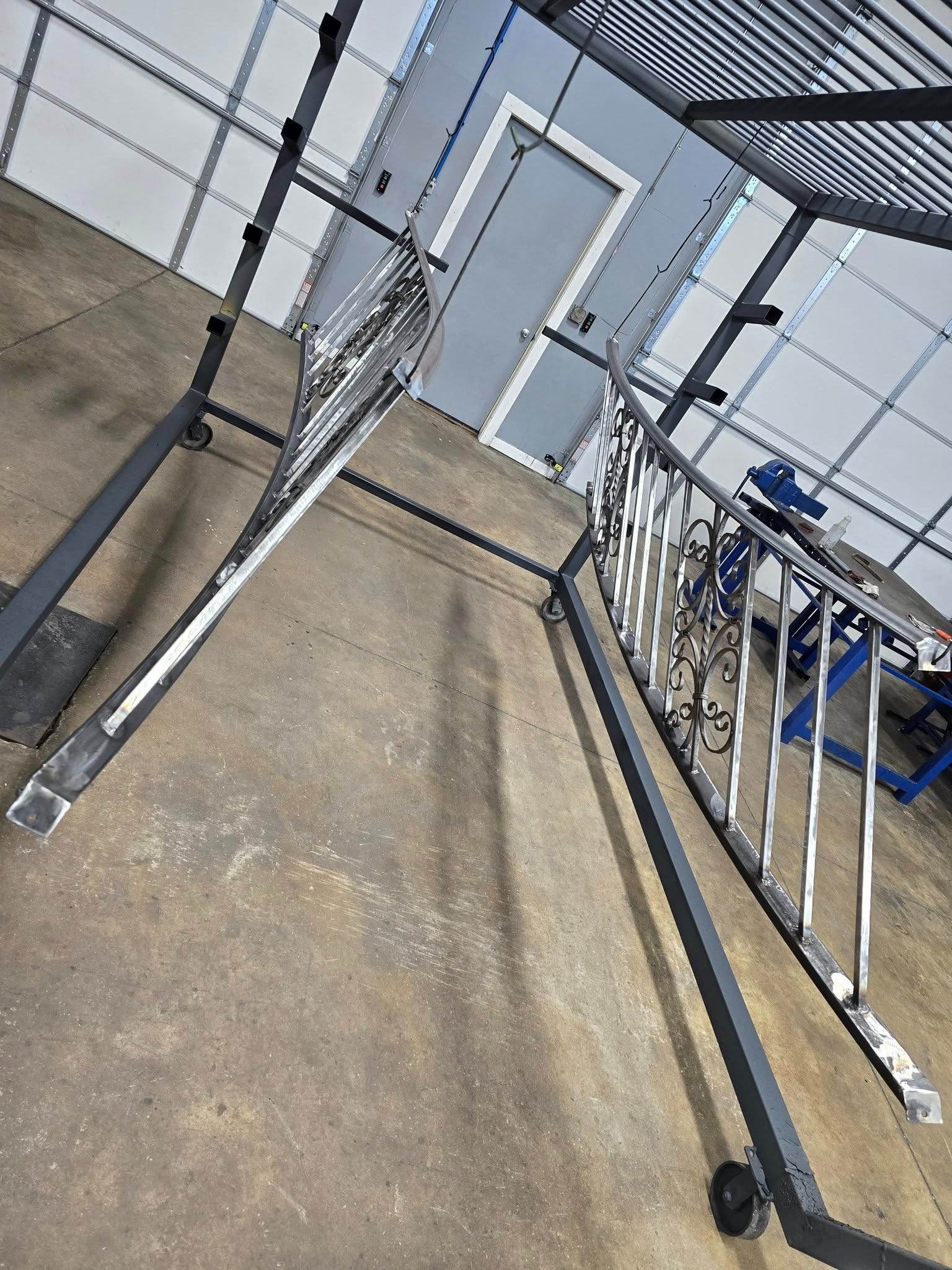 Tilted view of a metal accessibility ramp beside a building with a door and railings