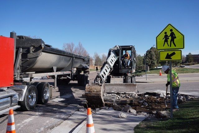 A construction site with a school crossing sign in the background