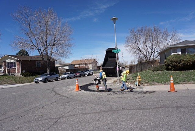 A group of construction workers are working on a street corner.