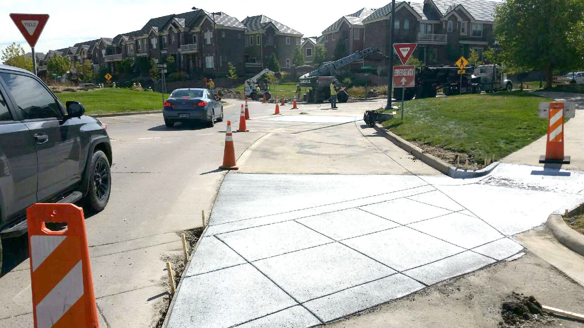 A car is driving down a street that is being remodeled