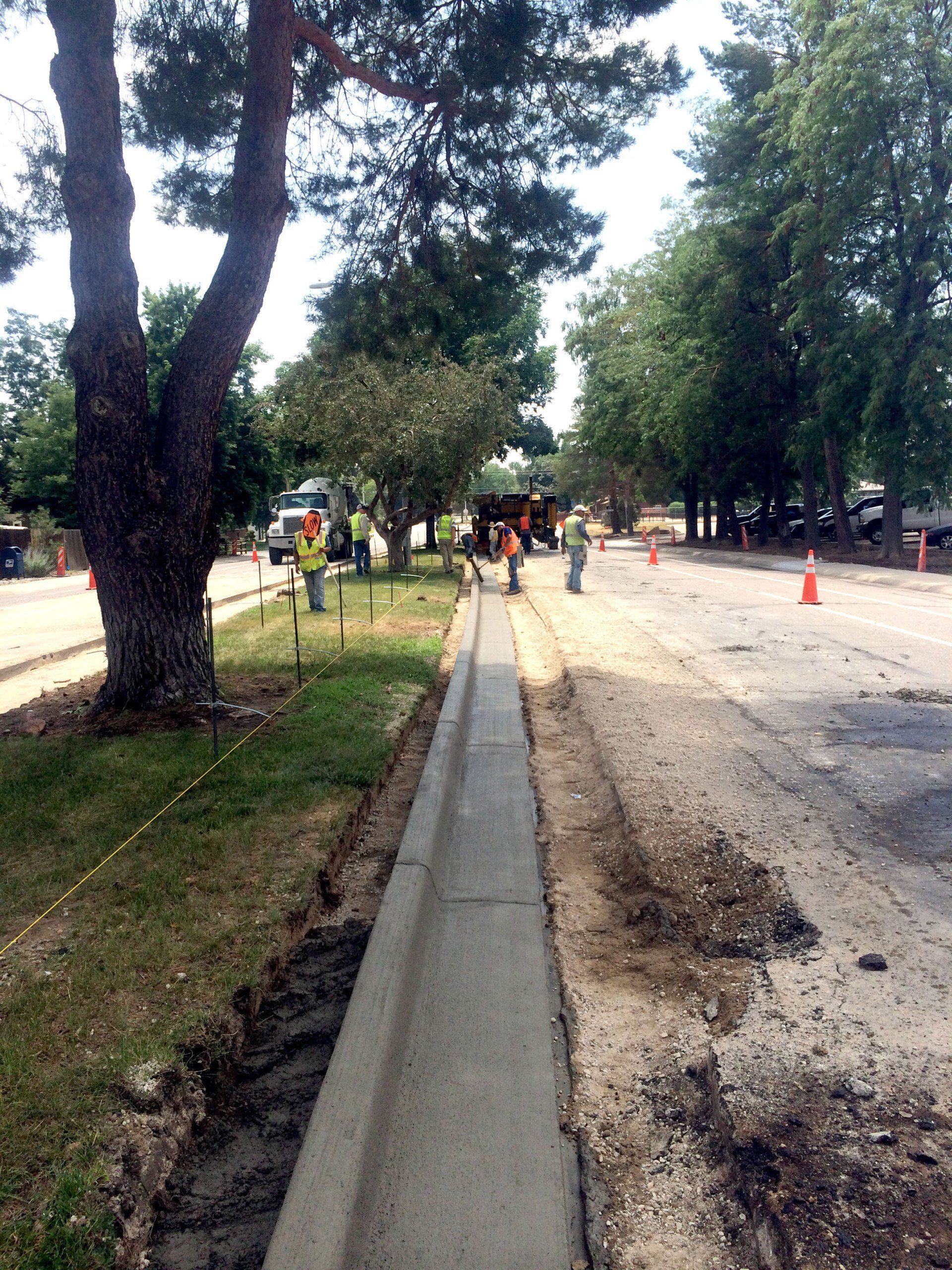 A concrete curb is being built on the side of a road