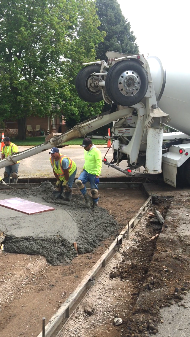 A concrete mixer truck is pouring concrete on a construction site.