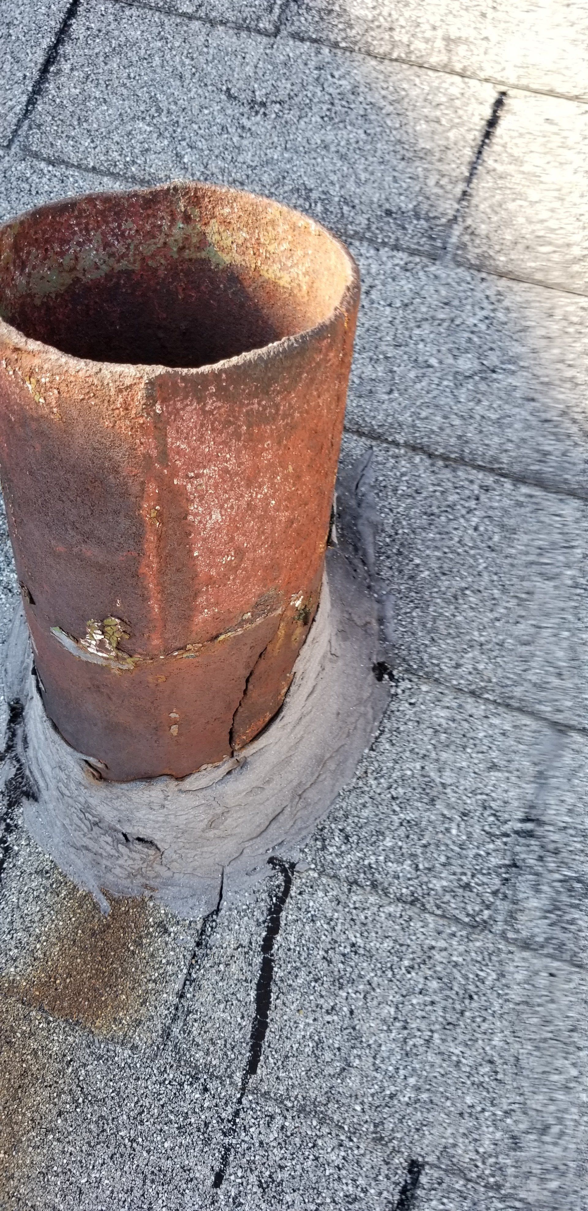 A clay pot is sitting on top of a brick floor.