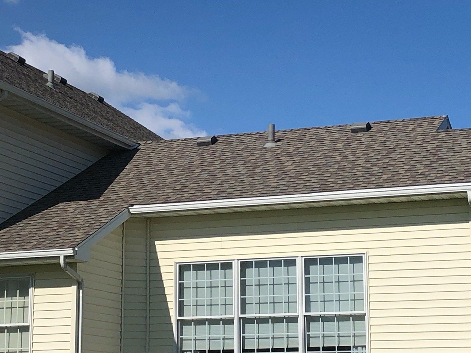 A house with a brown roof and white siding