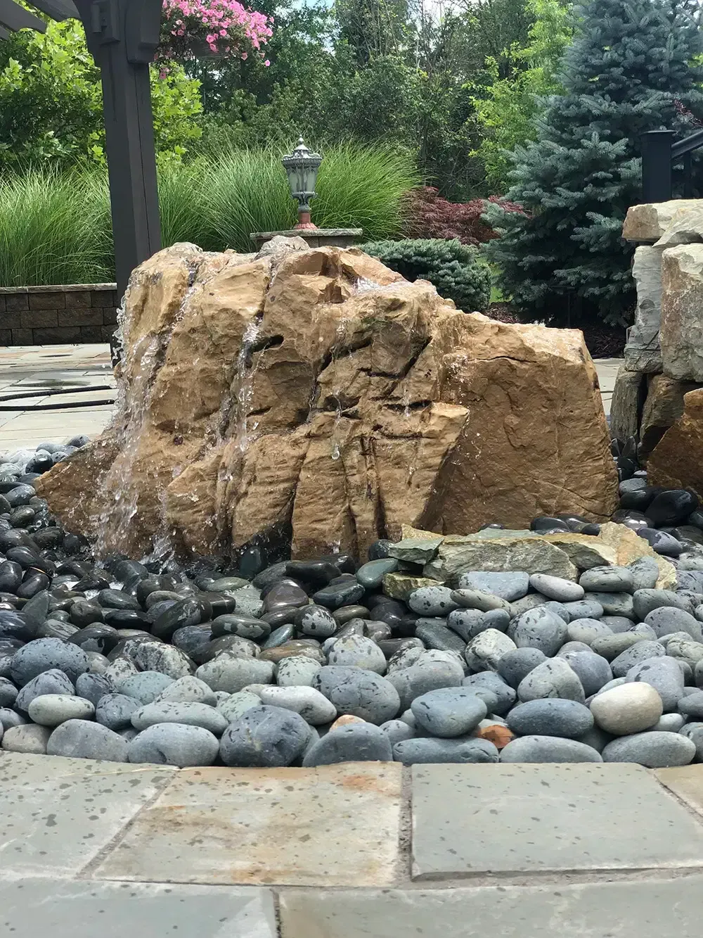Landscape rock with black stones and a garden lamp in a landscaped yard