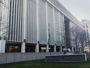 A large white building with a sign in front of it.