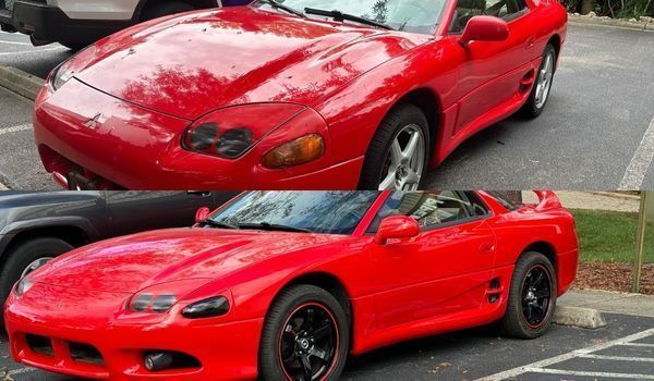 Two red Mitsubishi 3000GT sports cars side-by-side, parked outdoors. One has stock headlights, the other blacked out.