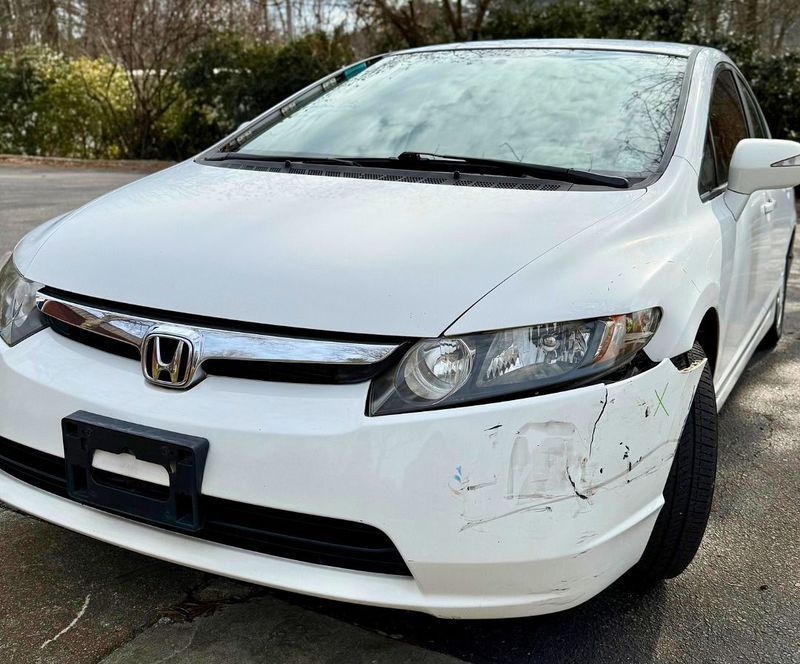 White Honda Civic with front bumper damage.
