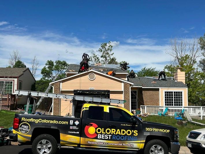 A colorado 's best roofing truck is parked in front of a house.