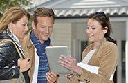 Real-estate agent with tablet showing house to clients