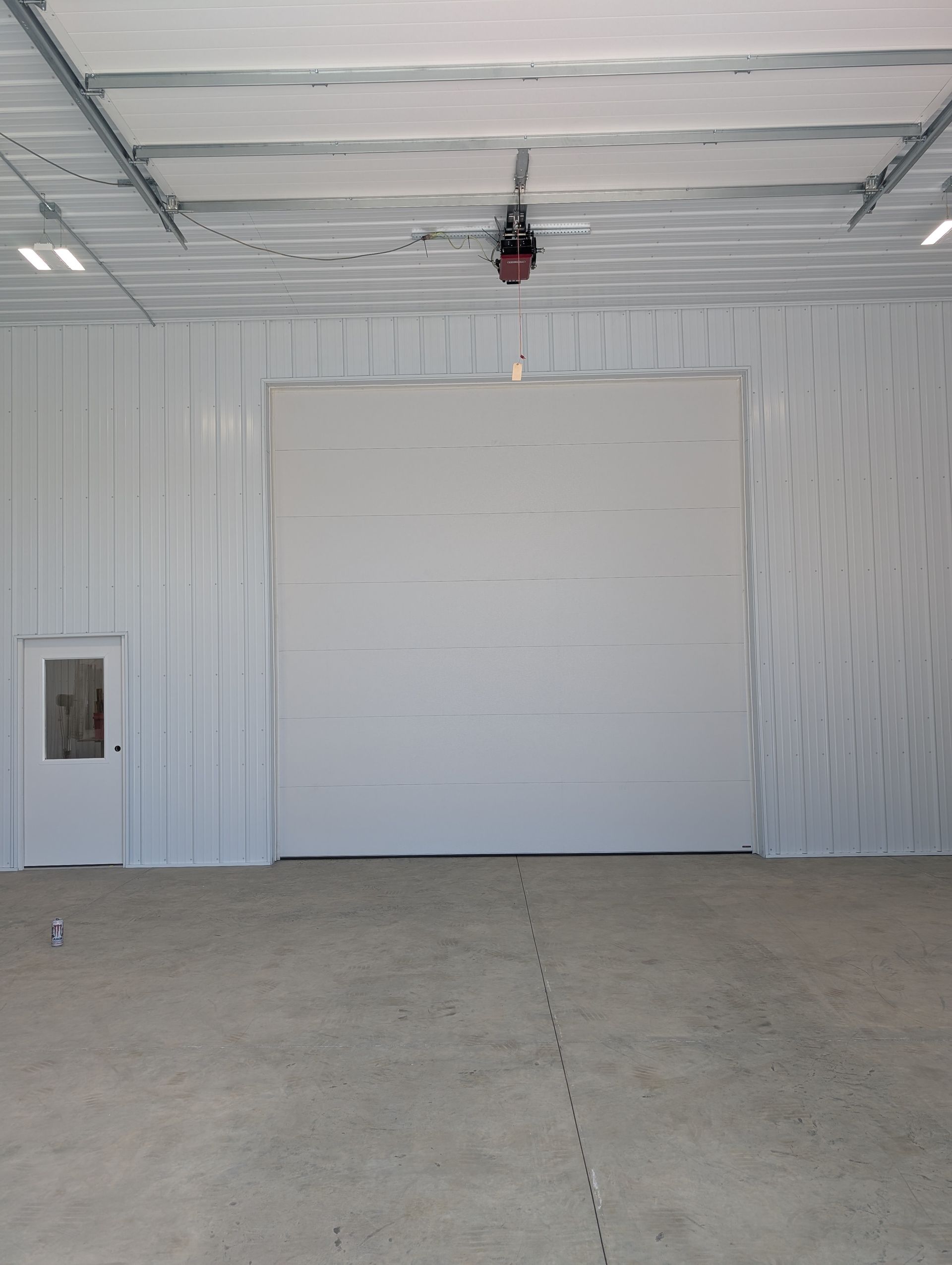 White garage interior with a closed overhead door and concrete floor