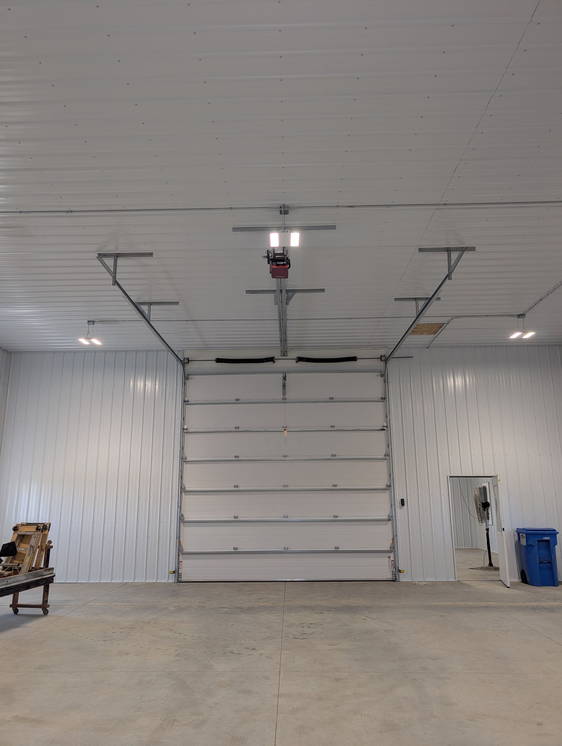 Empty garage interior with closed overhead door, white walls, and concrete floor
