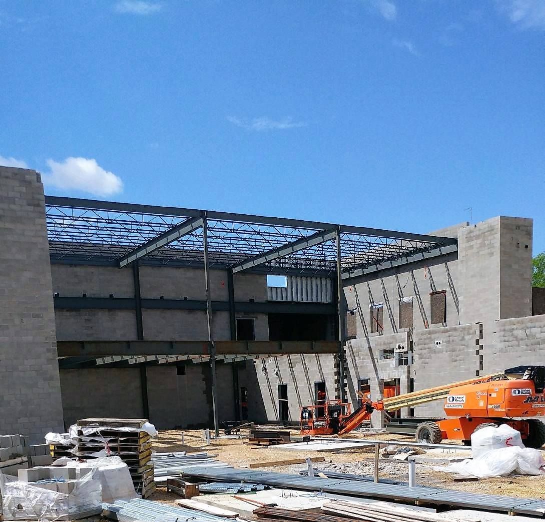 A large building under construction with a blue sky in the background.