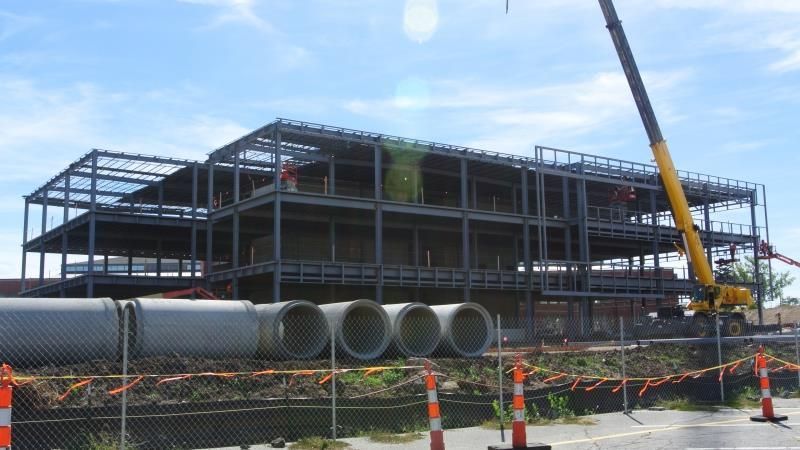A large building under construction with pipes in front of it