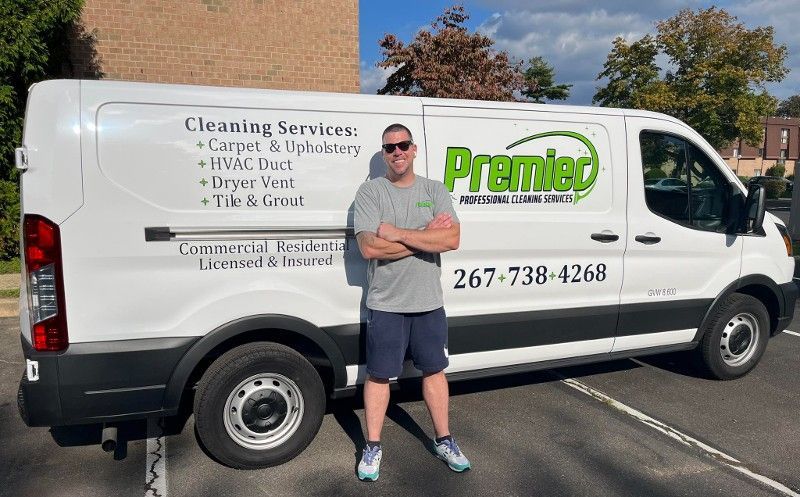 A man is standing in front of a cleaning service van.