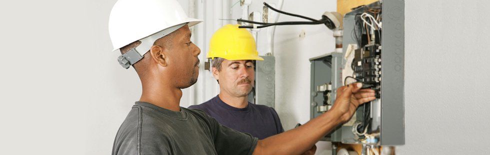 Two men electrician checking the breaker panels