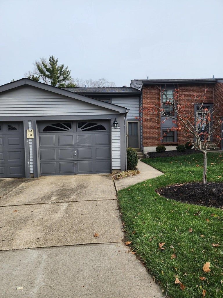 A house with a garage and a driveway in front of it.