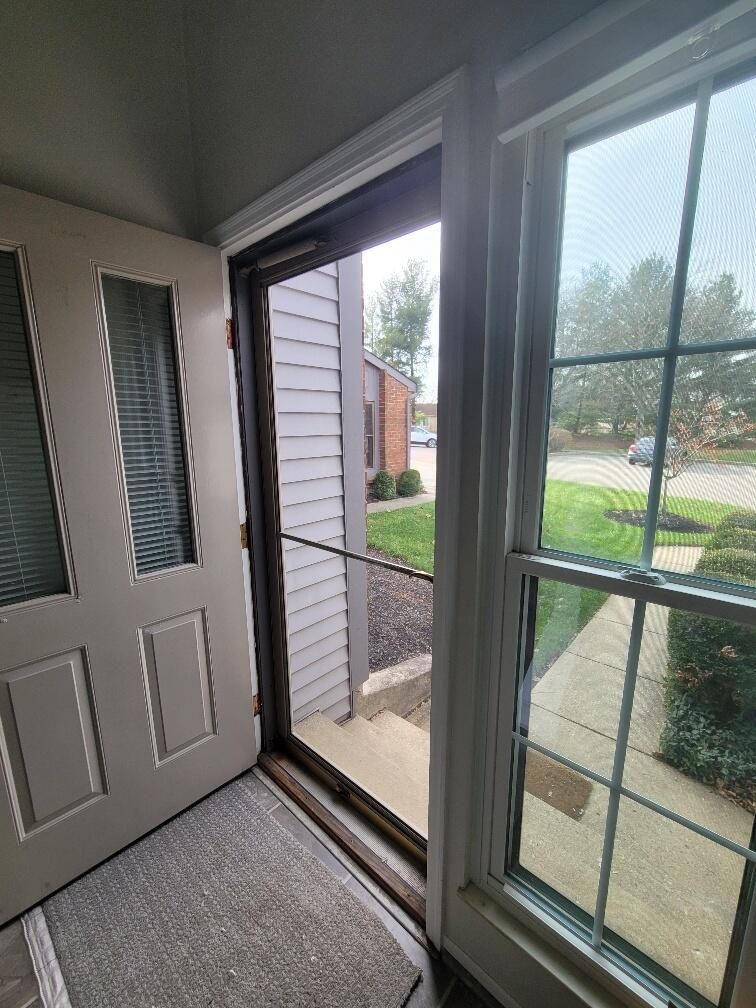 A room with a sliding glass door and two windows.