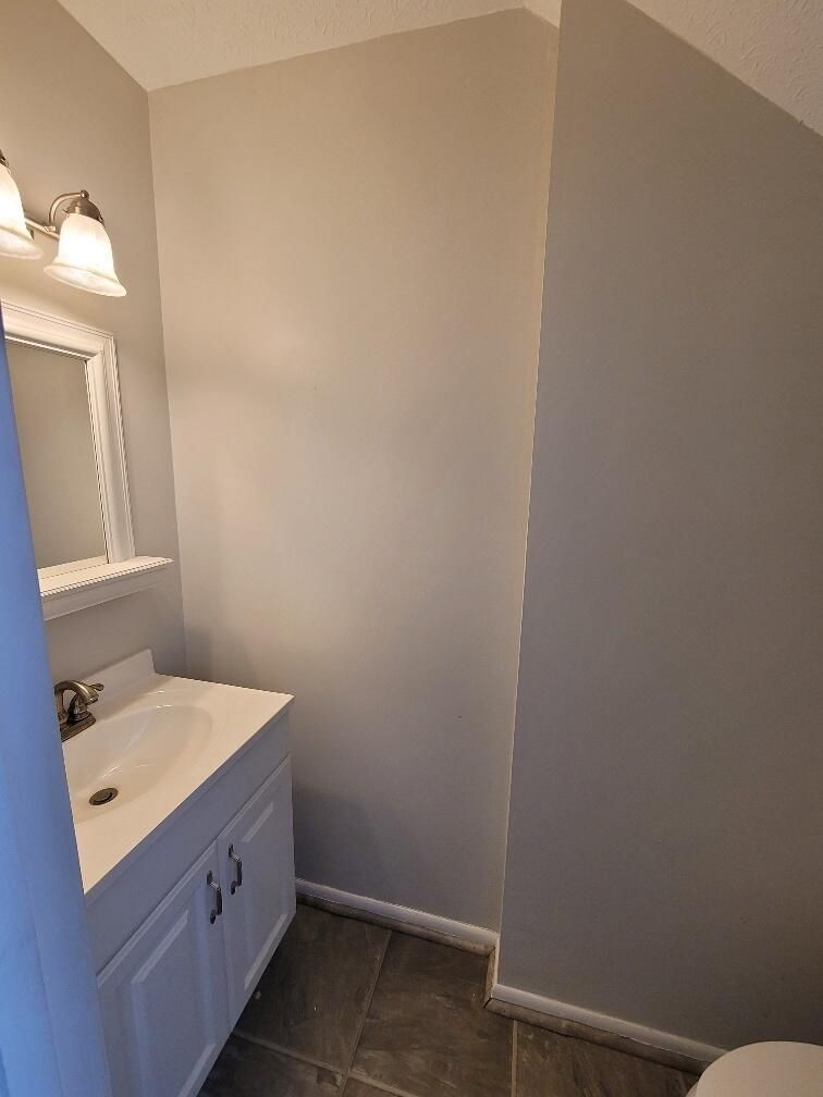 A bathroom with a sink, mirror and toilet.