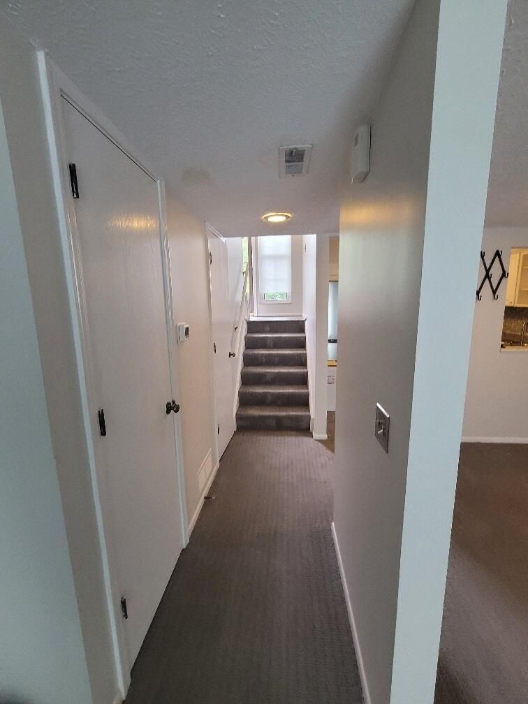 A hallway with stairs leading up to the second floor of a house.