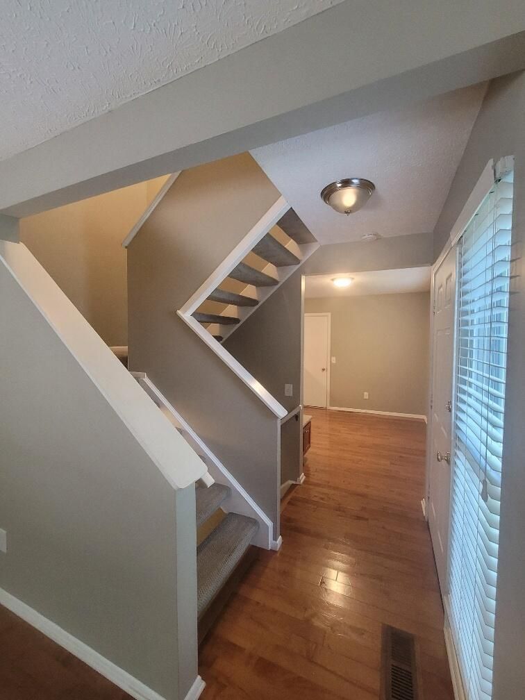 A hallway with stairs leading up to the second floor of a house.