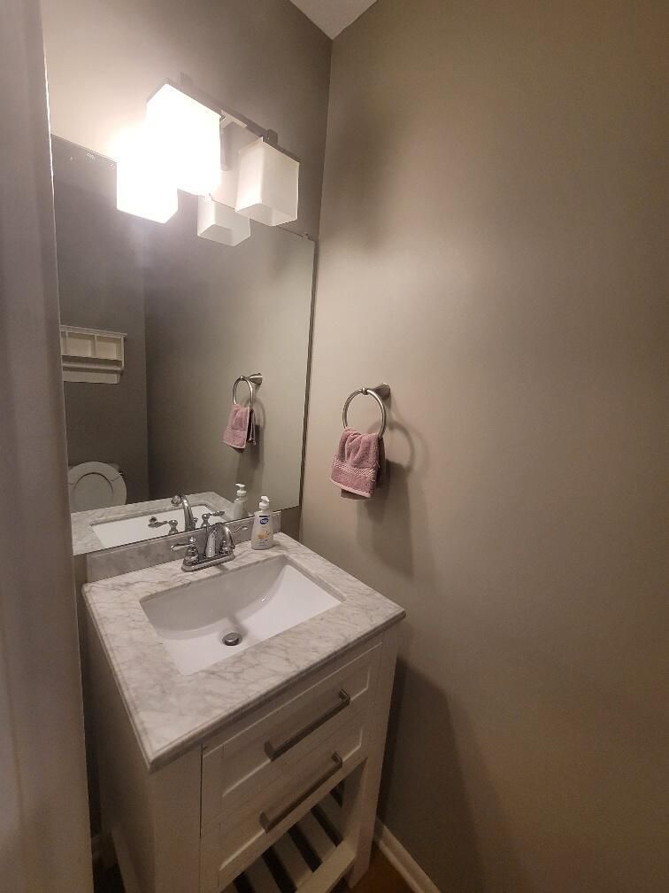 A bathroom with a sink, mirror and toilet.