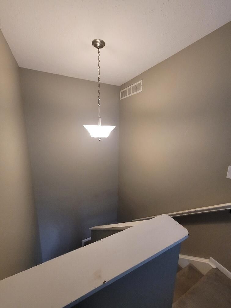 A staircase with a light hanging from the ceiling