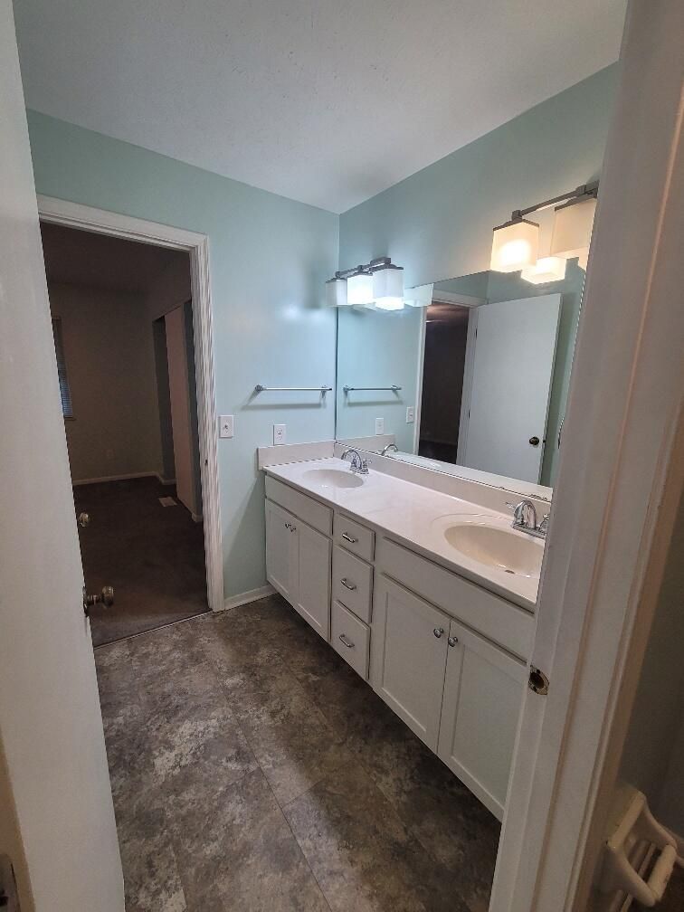 A bathroom with two sinks and a large mirror.