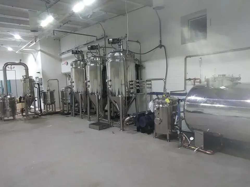 Stainless steel industrial tanks and pipes in a factory setting.