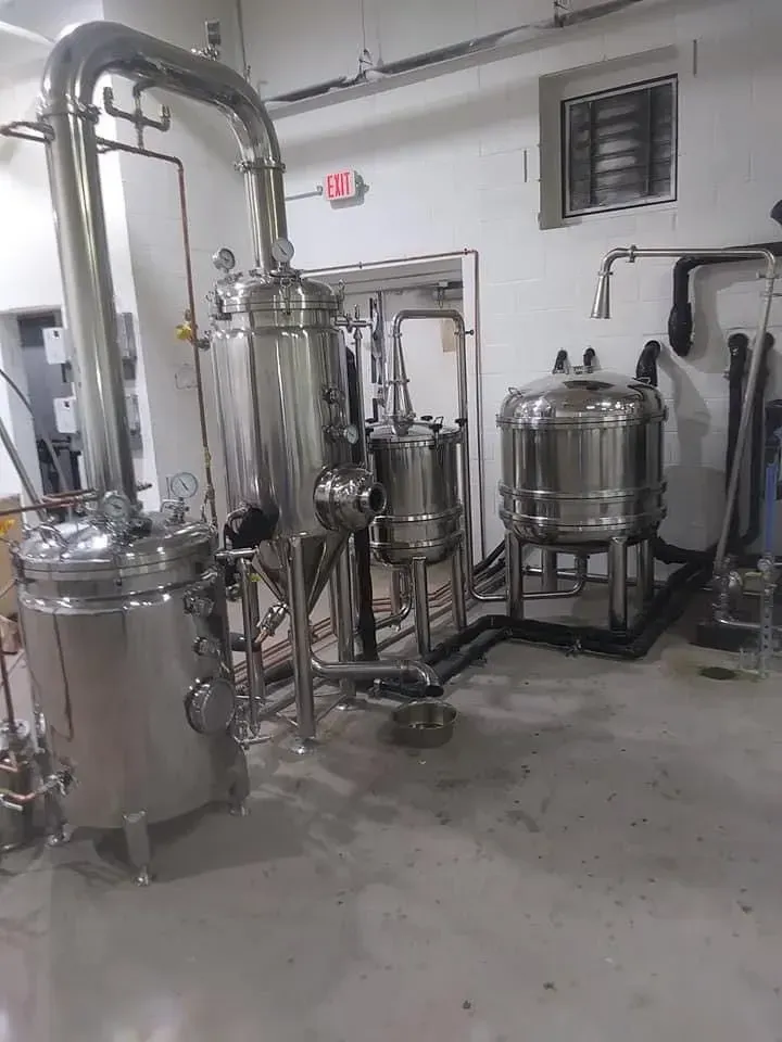Stainless steel industrial distillation equipment in a laboratory setting.