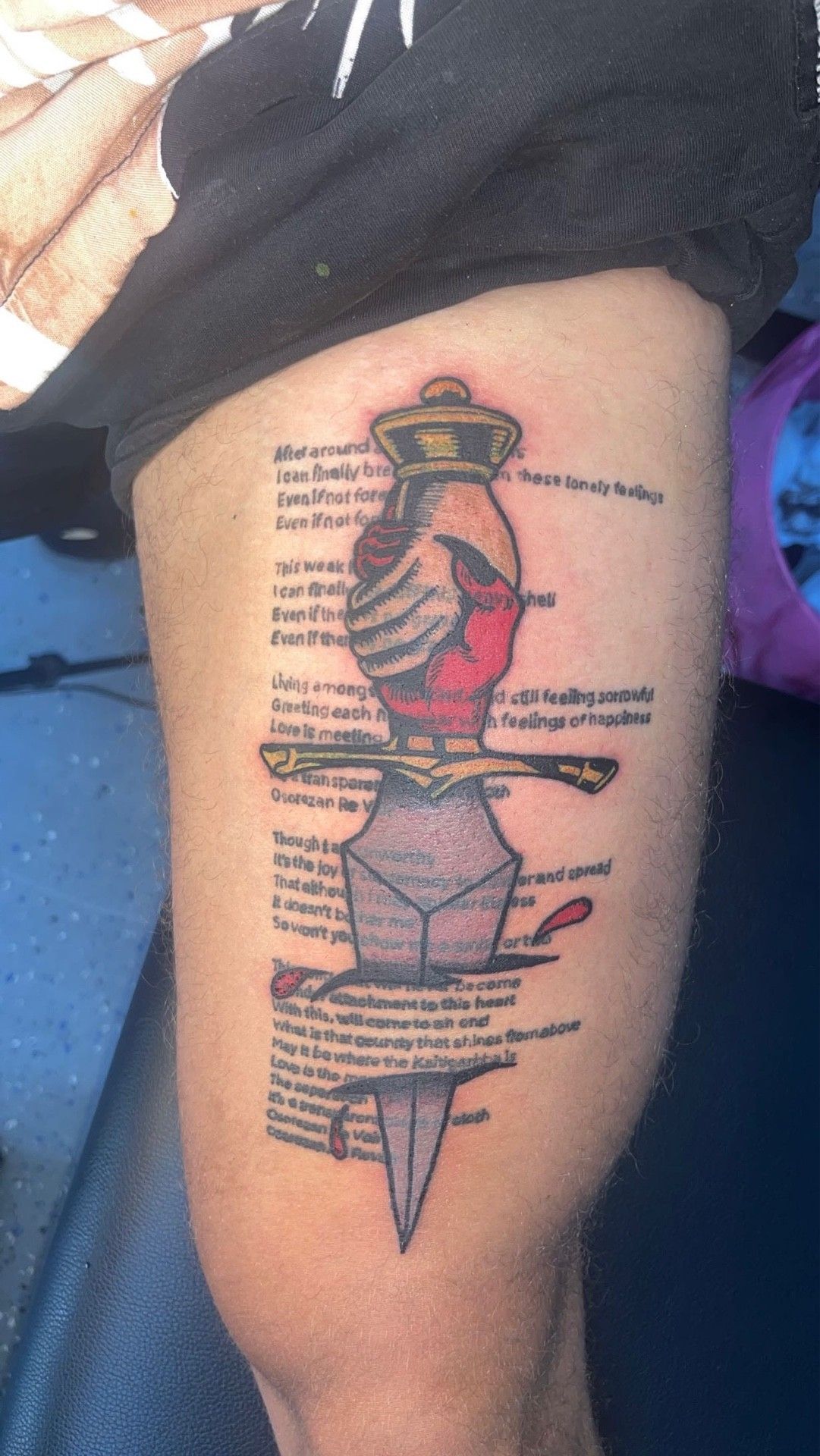 A person has a tattoo of a dagger on their leg.