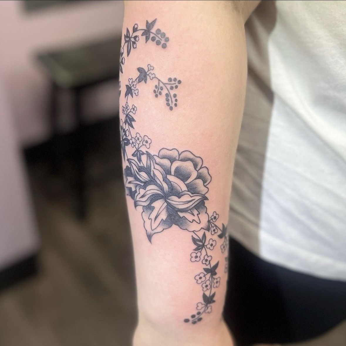 A woman has a tattoo of flowers on her arm