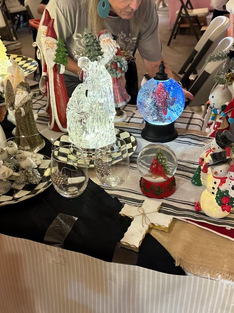 A woman is sitting at a table with christmas decorations on it.