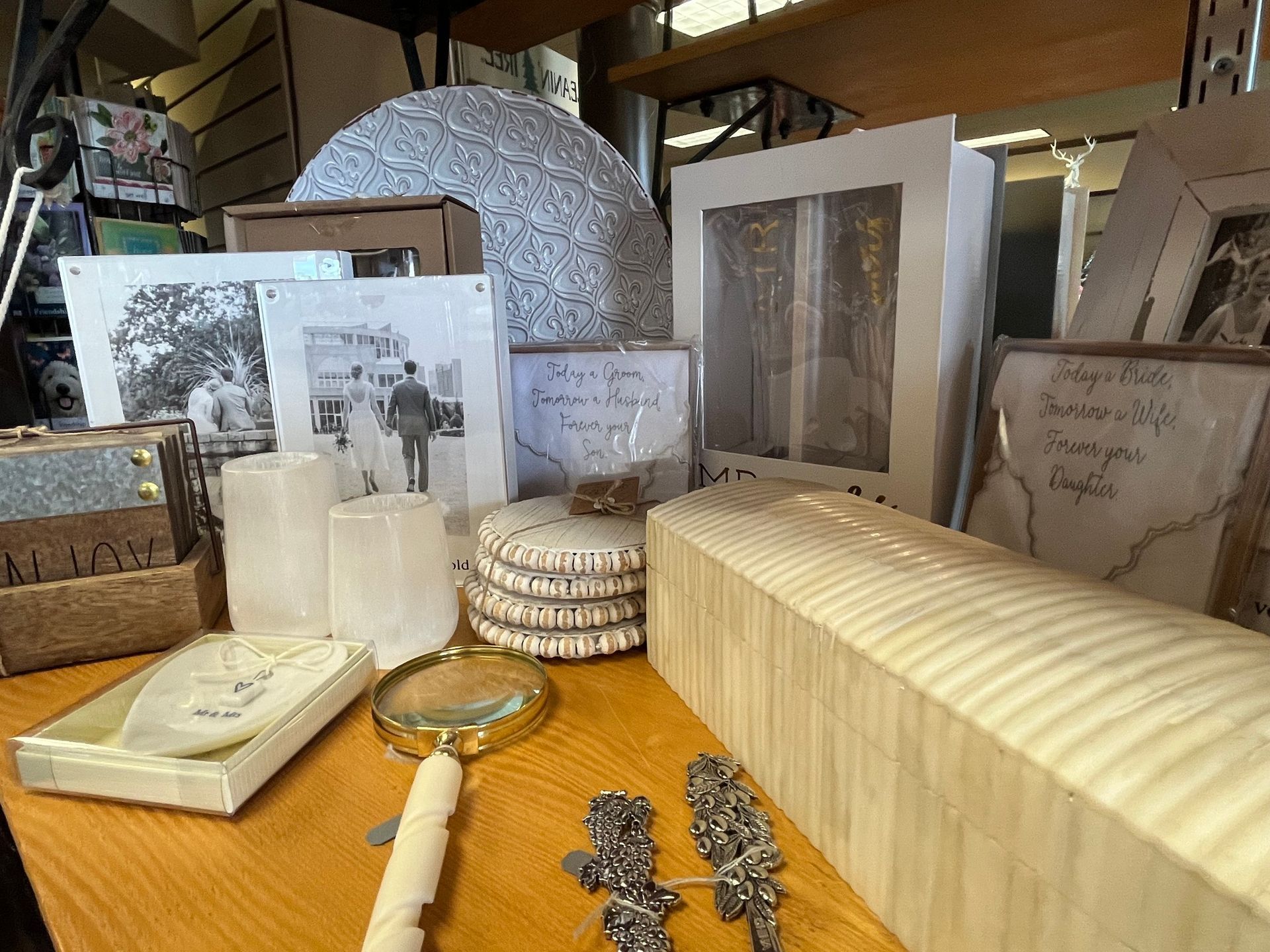A display of decorative items including photos, candles, and a magnifying glass on a wooden table.
