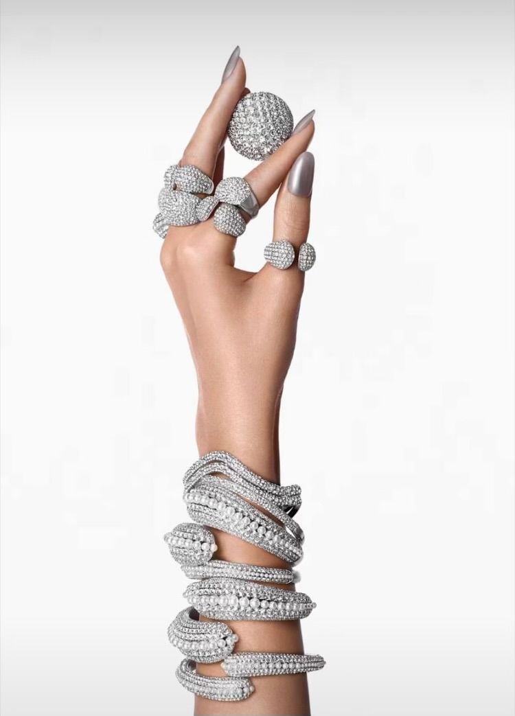 A woman 's hand with many rings and bracelets on it