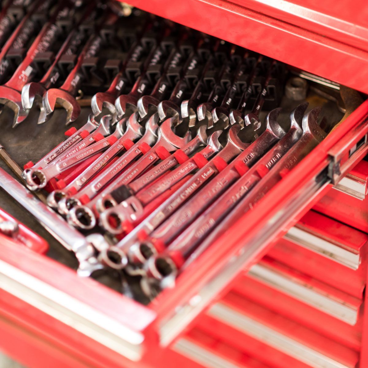 Red tool chest drawer filled with neatly arranged wrenches and socket tools