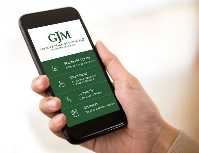 Hand holding a smartphone showing a GJM services app