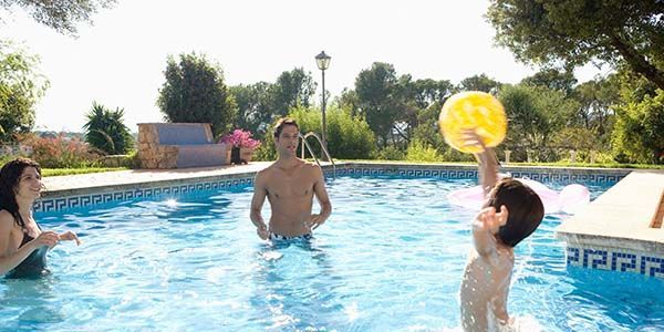 A group of people are playing with a ball in a swimming pool.