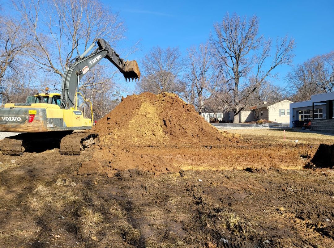 A bulldozer is digging a pile of dirt in a field.