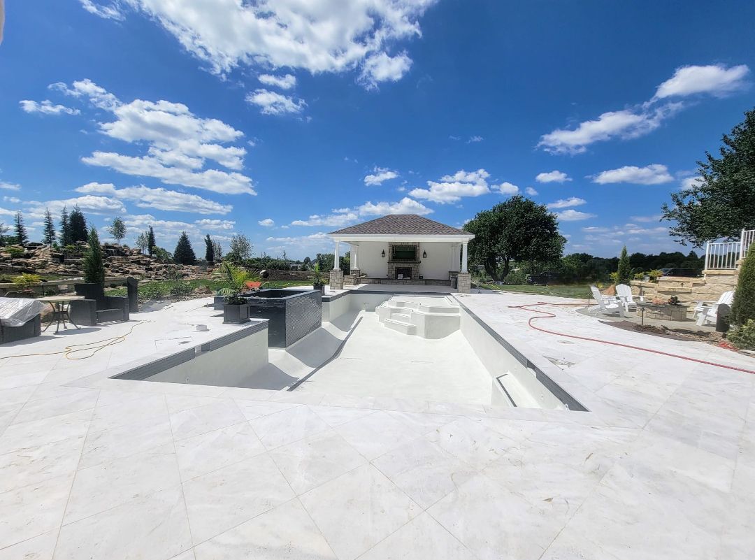 A large swimming pool is being built in the backyard of a house.