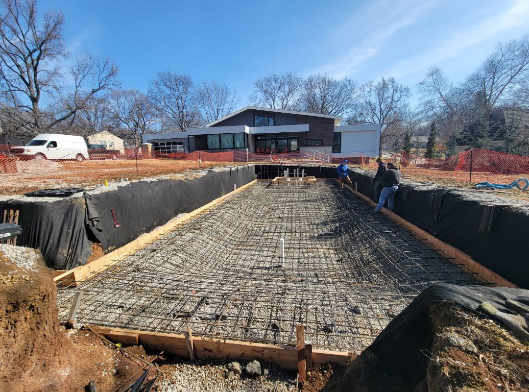 A large swimming pool is being built in front of a house.
