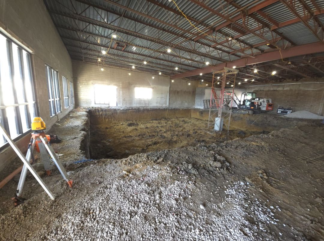 A large building under construction with a large hole in the ground.