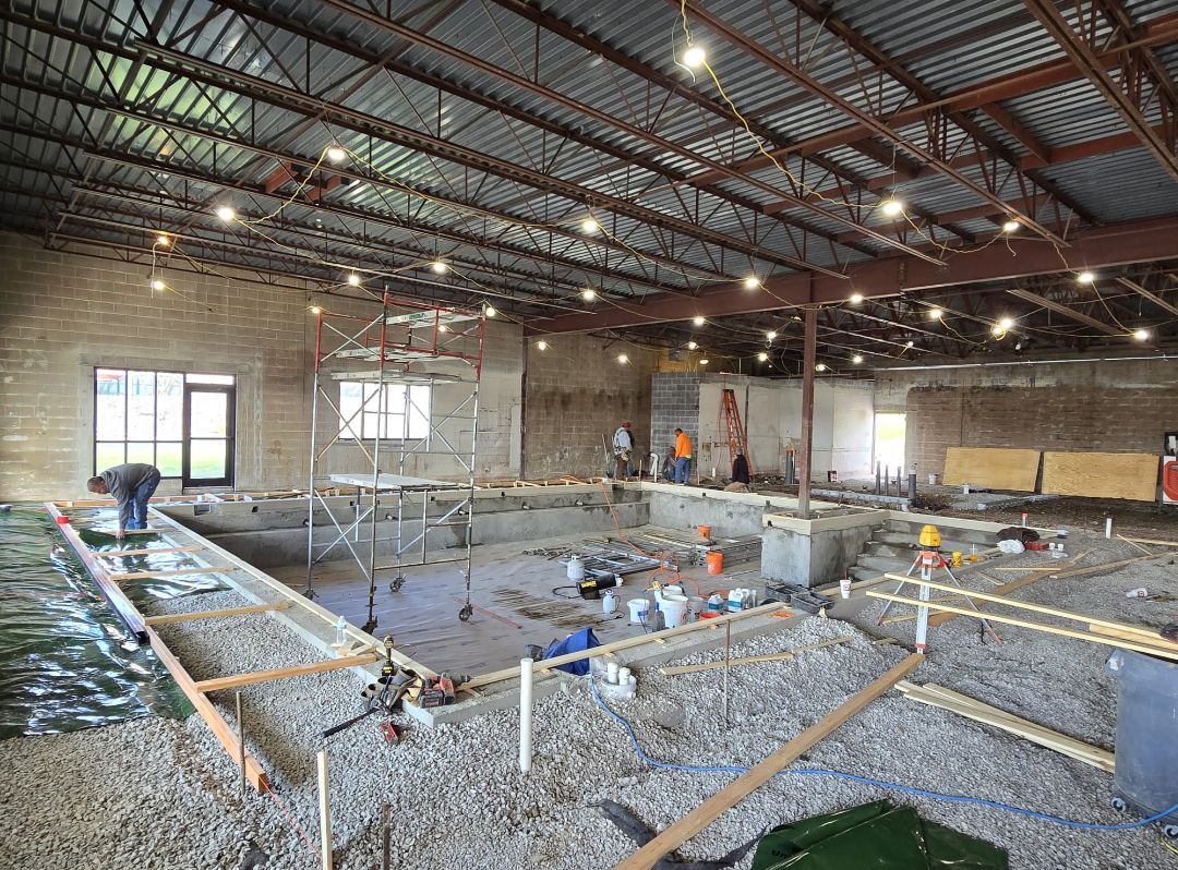 A large building under construction with a swimming pool in the middle.