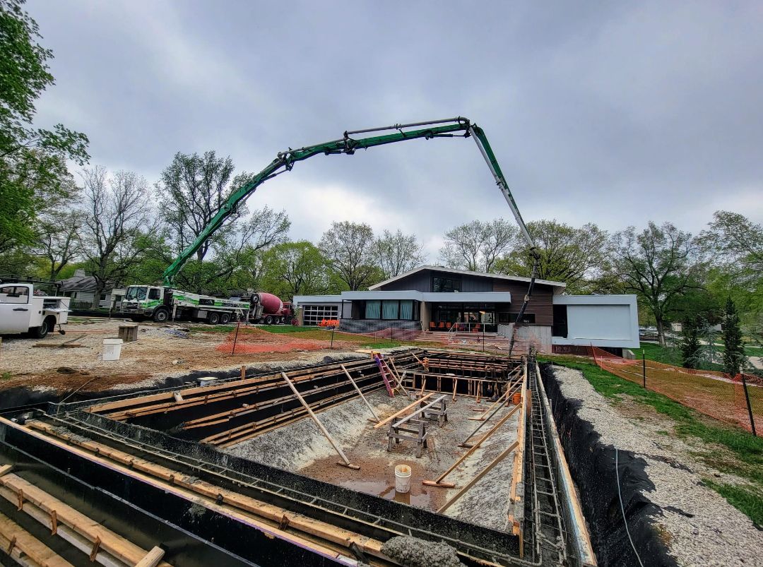 A concrete pump is being used to pour concrete into a pool.