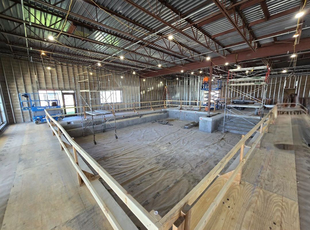 A large swimming pool is being built in a building under construction.