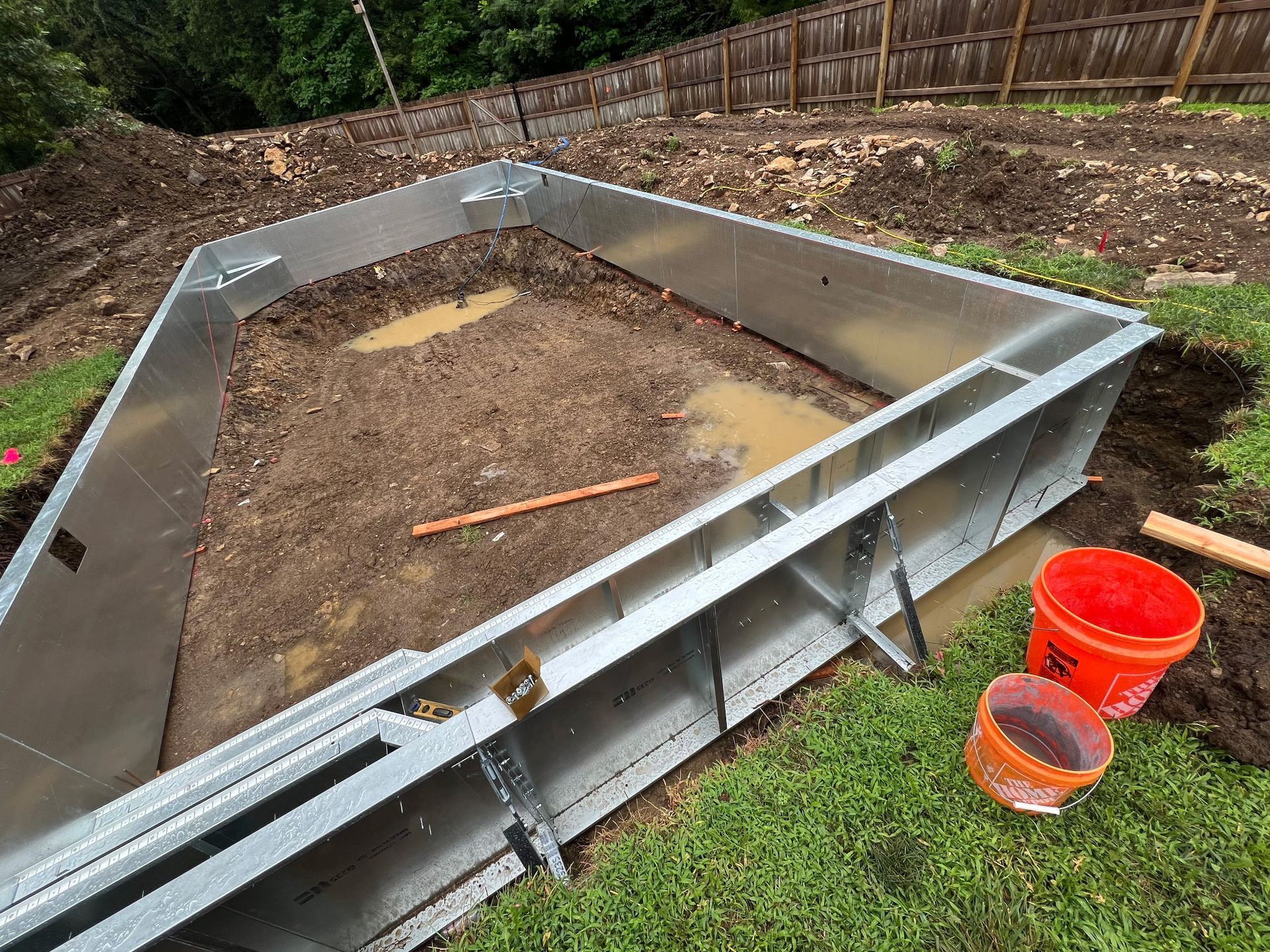 metal pool frame installed in a muddy construction site