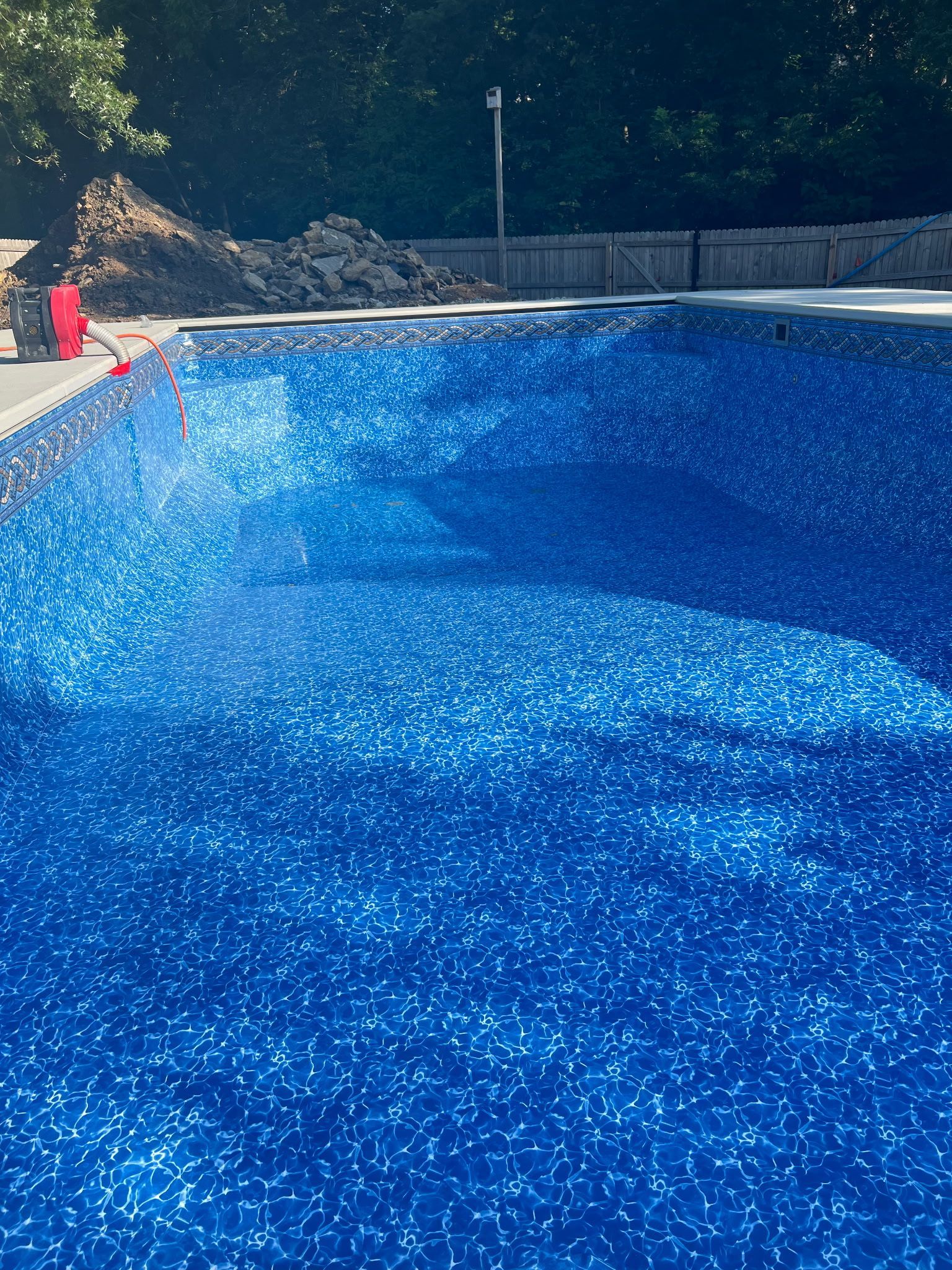 blue swimming pool being filled with water