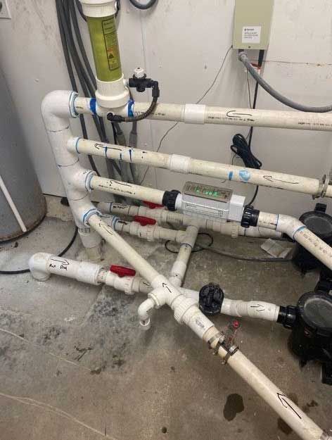 pool equipment, white PVC pipes with valves and flow meter