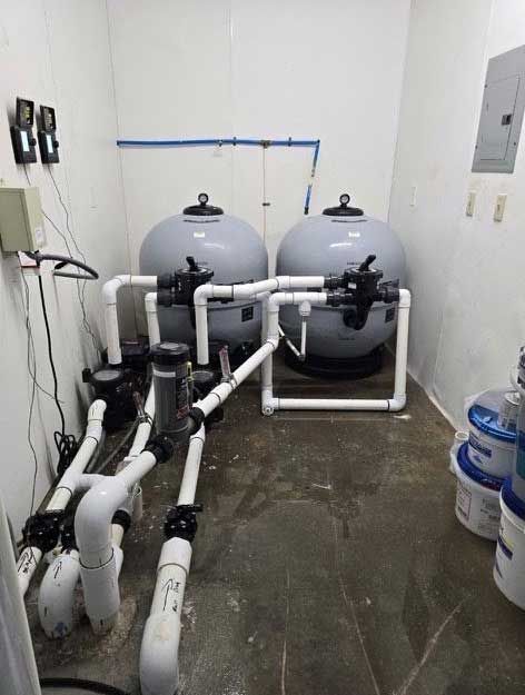 pool equipment room with two large filters, plumbing, and pumps